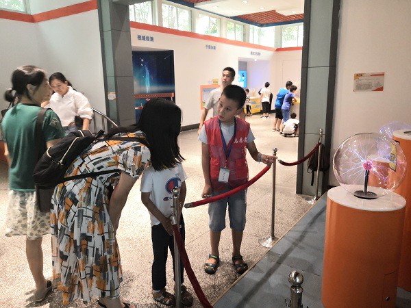 1535678448315038461.jpg 小志愿者耐心地为观众讲解辉光球展品.jpg